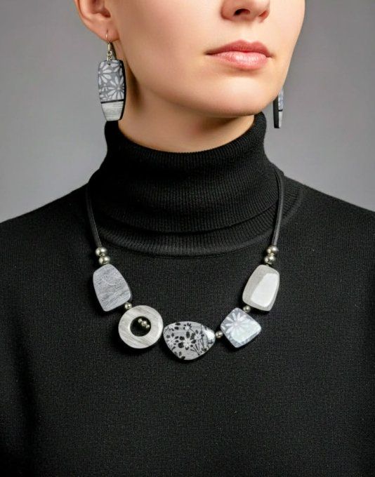 Collier contemporain en argile polymère noir et blanc avec motifs géométriques et floraux contrastés