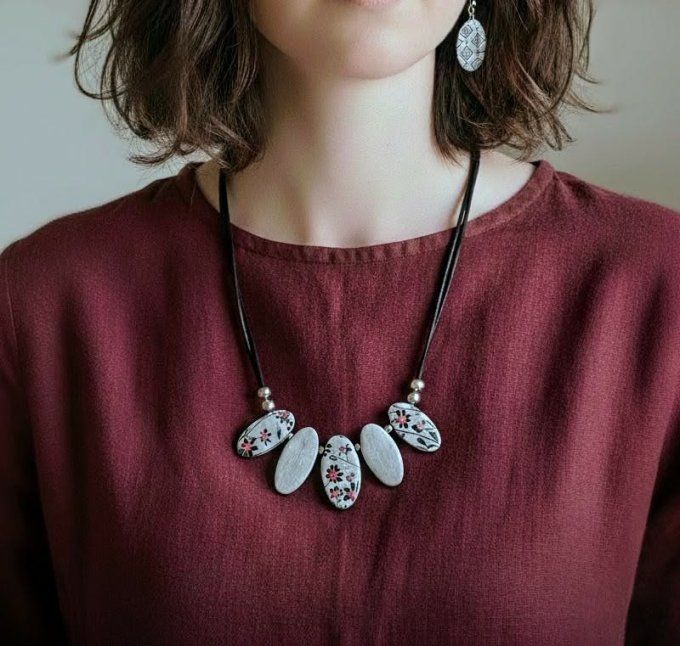 Bijou fait main délicat composé de cinq pendentifs en polymère gris clair avec des motifs floraux li