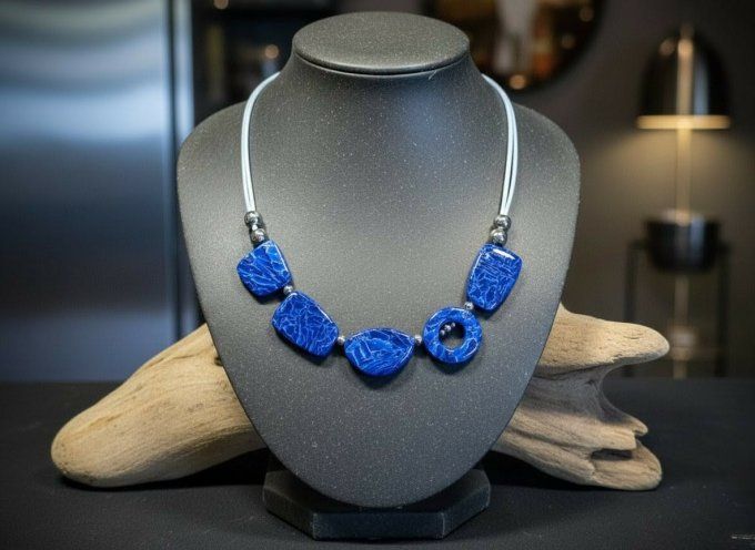 Collier artisanal bleu saphir en argile polymère composé de perles géométriques plates, monté sur un