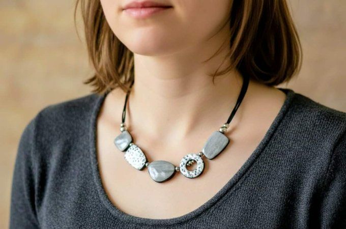 Collier artisanal en pâte polymère grise avec motifs de notes de musique et perles en acier inoxydab