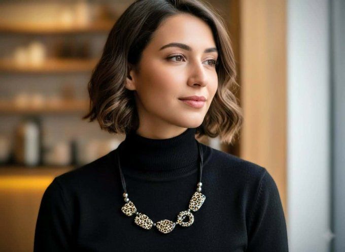 Collier artisanal noir et doré en argile polymère avec motifs organiques, monté sur un cordon noir é