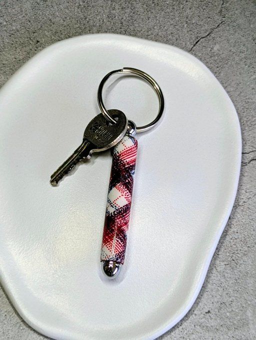 Porte-clé artisanal cylindrique en argile polymère avec motif tartan rouge et bleu marine, monté sur